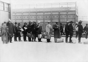Vintage photo circa 1911 of immigrants queuing up to be processed at Ellis Island in New York.