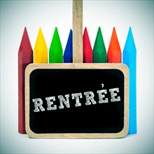 rentree, back to school written in french in a blackboard label and some crayons of different colors, with a retro effect