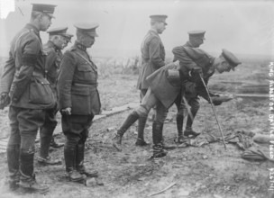 King Albert on Battle Field, Photograph shows an aide-de-camp of King Albert I of Belgium picking up a souvenir on the Somme battlefield near Pozieres, France, May 16, 1917. King Albert I and General ...